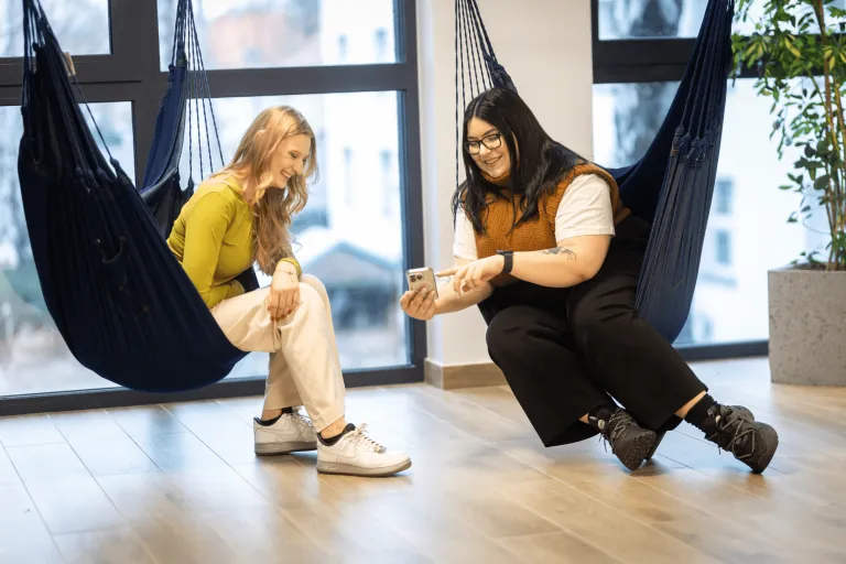 Information Technology | WSB Merito Gdańsk University: Studentki siedzą w hamakach i oglądają rzecz na komórce