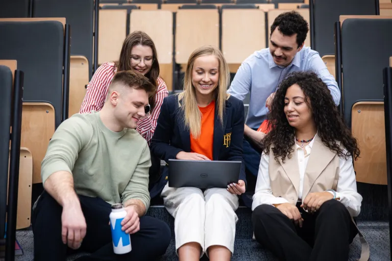 Software Development | WSB Merito Gdańsk University: Studenci siedzą na auli w grupie przy laptopie