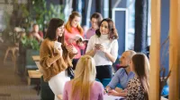 Marketing and Sales | WSB Merito Łódź University: Grupa ludzi rozmawia przy stole.