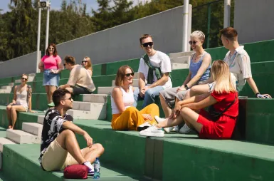 Student organisations and research clubs | WSB Merito Łódź University: Grupka studentów siedzi na schodach i rozmawia ze sobą