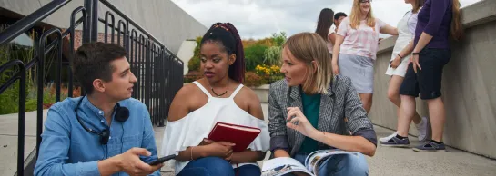 Department of International Relations | WSB Merito Łódź University: Grupka studentów siedzi na schodach i rozmawia ze sobą