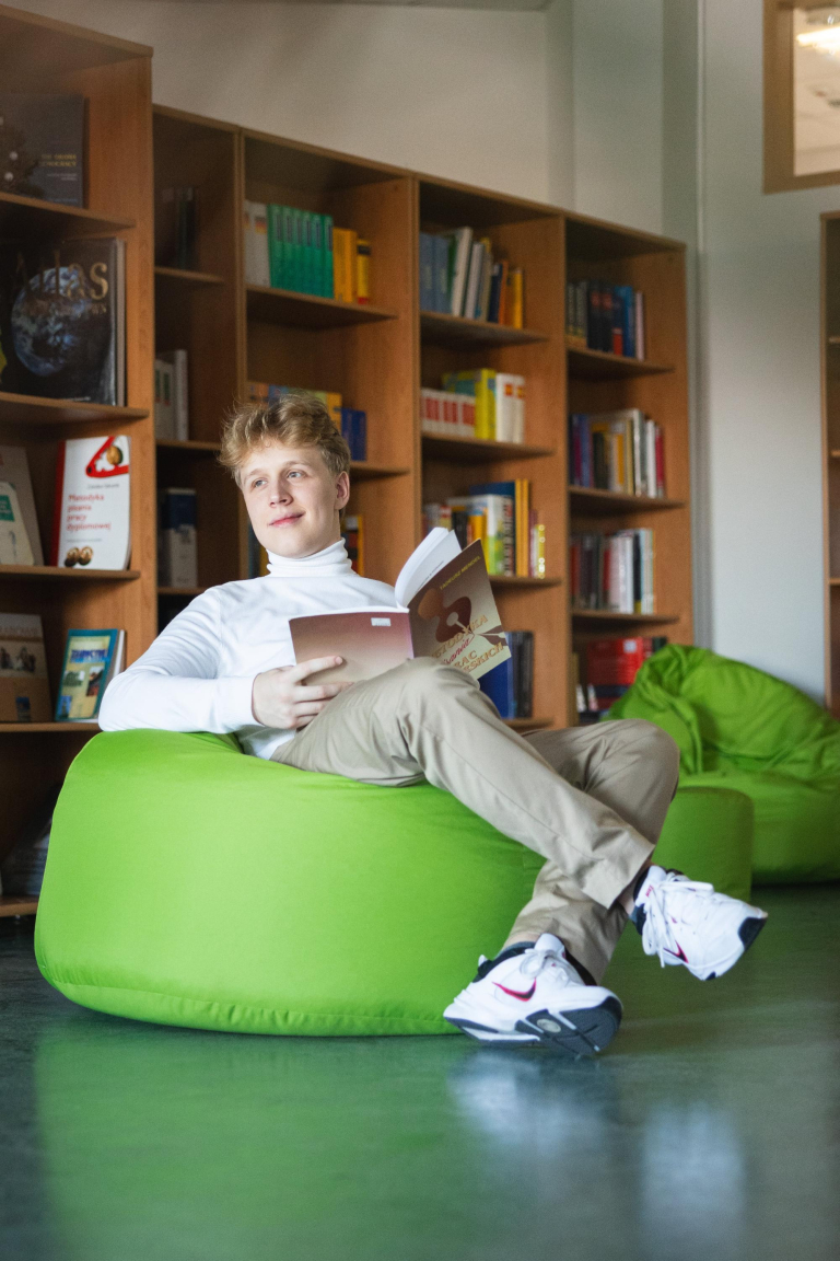 Disability Support Officer | WSB Merito Łódź University: Uczeń czyta książkę w bibliotece Uniwersytetu WSB Merito w Łodzi