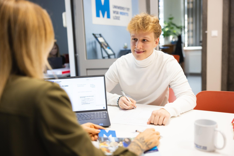 Master's degree | WSB Merito Łódź University: Student podpisuje dokumenty na Uniwersytecie WSB Merito w Łodzi