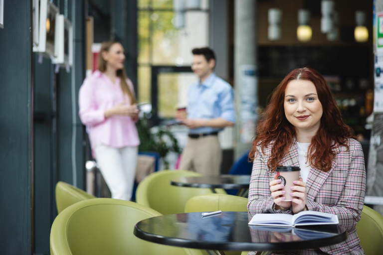 Master's degree | WSB Merito Opole University: Grafika główna: Opole_osiągnięcia naukowe_dziewczyna siedzi przy stoliku w kawiarni