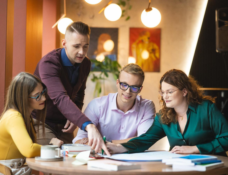 Transfer from another university | WSB Merito Opole University: Grupa młodych osób siedzi przy stole i pracuje nad projektem