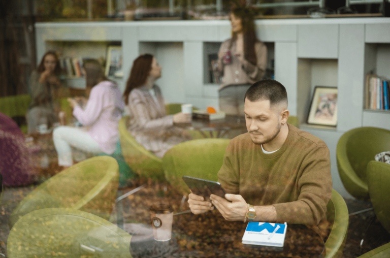 Digital university | WSB Merito Opole University: Student korzystający z tabletu. Siedzi w kawiarni