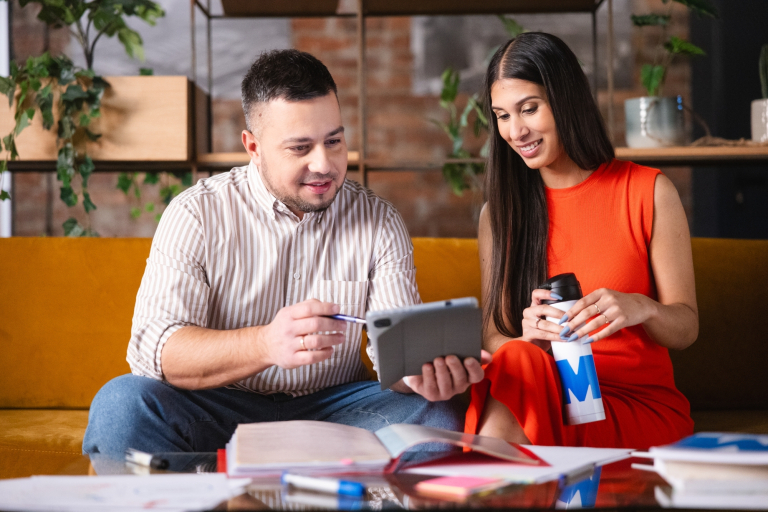 Digital university | WSB Merito Opole University: Studenci siedzą na kanapie, uczą się używając tabletu