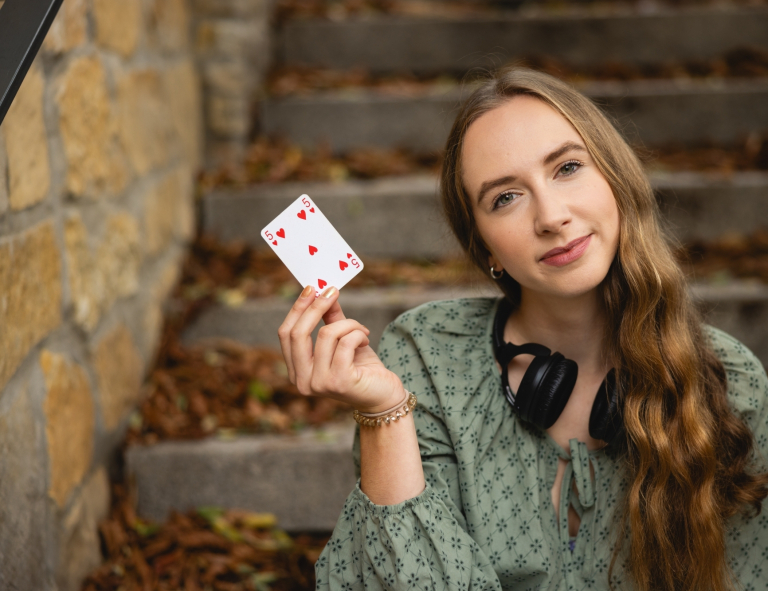 International Management, studia II stopnia, magisterskie: Dziewczyna siedząca na schodach, w dłoni trzyma kartę do gry