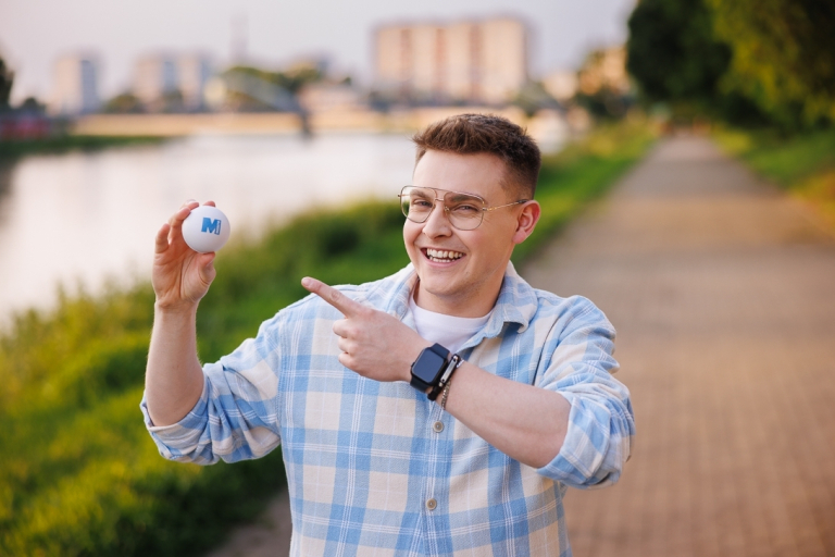 Our values | WSB Merito Opole University: Chłopak wskazujący na piłeczkę antystresową z logotypem Uniwersytetu WSB Merito