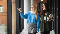 Advanced Database Systems | WSB Merito Poznań University: Dwie studentki, kolorowo ubrane spacerują po korytarzu uczelni WSB Merito w Poznaniu 