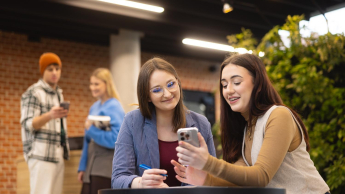 Our campus | WSB Merito Poznań University: Poznań - dwie studentki ze smartfonem