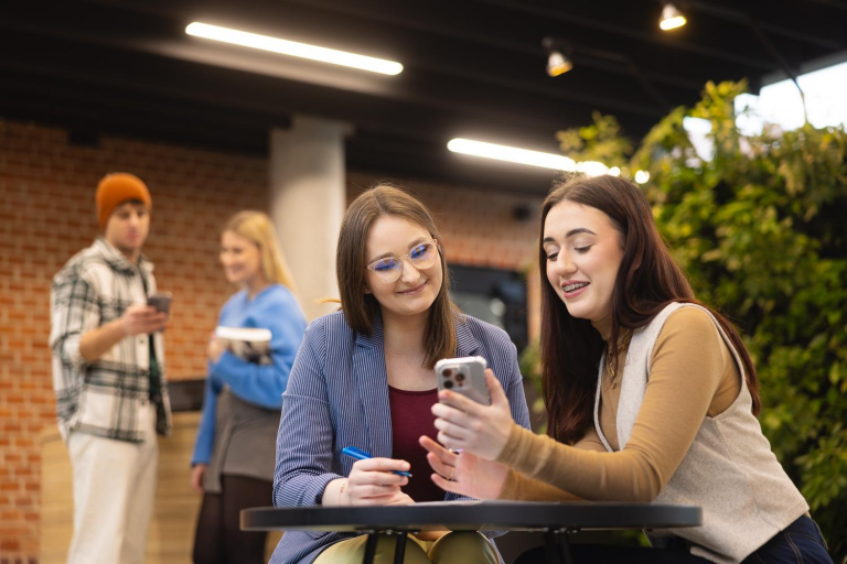 Digital university | WSB Merito Poznań University: Poznań - dwie studentki ze smartfonem