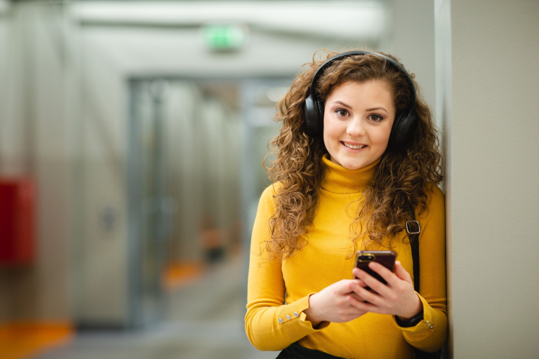 Student Council | WSB Merito Poznań University: Studentka WSB Merito Poznań słucha muzyki na korytarzu uczelni