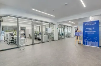 Our campus | Uniwersytet WSB Merito Szczecin: Hol wejściowy WSB Merito w Szczecinie. Za szklanymi ścianami widać działy Administracyjne.