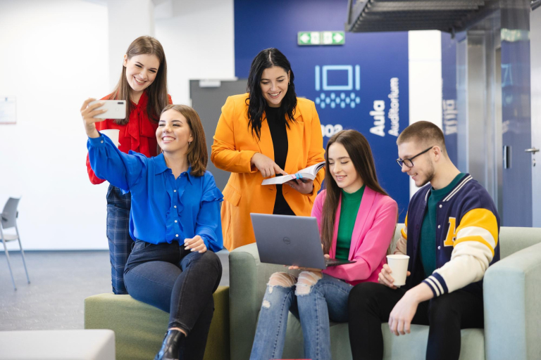 Digital university | Uniwersytet WSB Merito Szczecin: Studenci Uniwersytetu WSB Merito robiący sobie zdjęcie i uczący się wspólnie na korytarzu uczelni