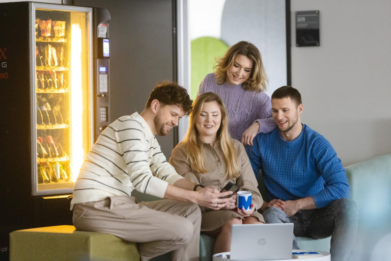 Digital university | Uniwersytet WSB Merito Szczecin: Grupa studentów Uniwersytetu WSB Merito patrząca w telefon w strefie relaksu