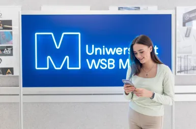 Our campus | WSB Merito Toruń University: studentka na korytarzu uczelni