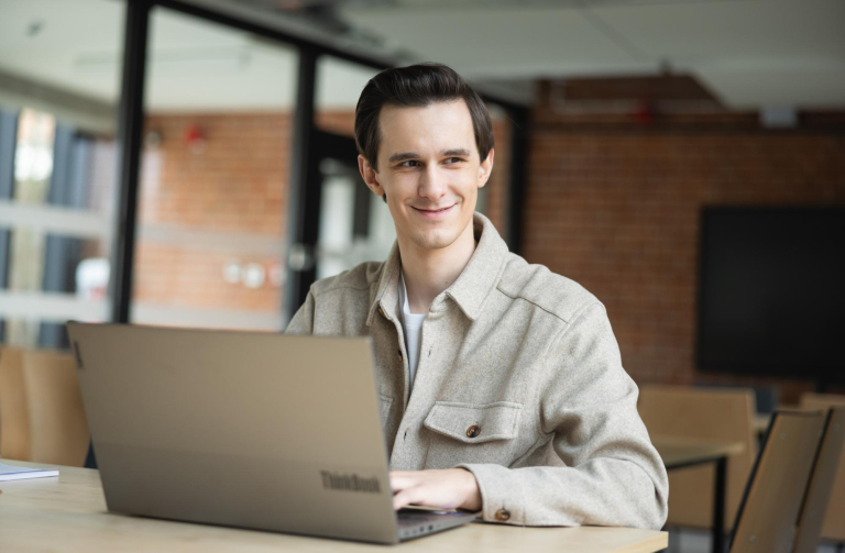 Digital university | WSB Merito Toruń University: student siedzi przy biurku i przed laptopem