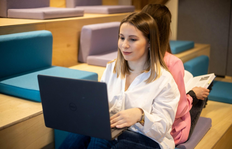 Digital university | WSB Merito Toruń University: studentka z laptopem na kolanach