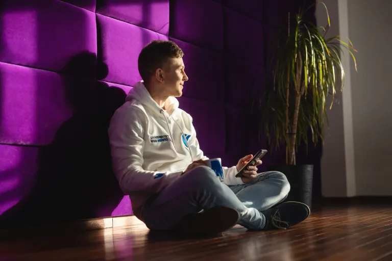 Web Application Developer, studia I stopnia, licencjackie i inżynierskie: Główna grafika: Toruń - studia I stopnia - student oparty o fioletową ścianke