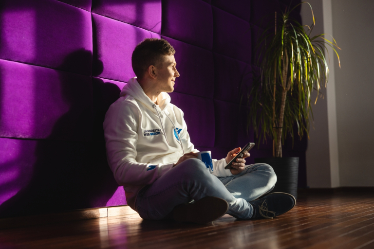 Web Application Developer, studia I stopnia, licencjackie i inżynierskie: Główna grafika: Toruń - studia I stopnia - student oparty o fioletową ścianke