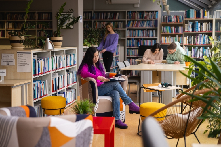 Our campus | WSB Merito Toruń University: Główna grafika: Toruń - studia I stopnia - studentka w bibliotece