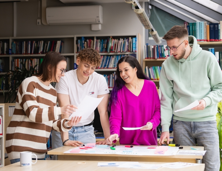 Finance and Accounting, studia I stopnia, licencjackie i inżynierskie: Główna grafika: Toruń - studia I stopnia - grupa uśmiechniętych studentów w bibliotece