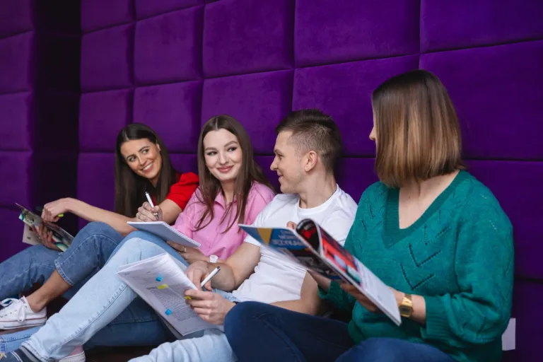 Finance and Accounting | WSB Merito Toruń University: Grupa studentów siedzi z książkami na fioletowym tle