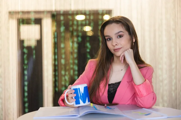 Web Application Developer | WSB Merito Toruń University: Główna grafika: Toruń - studia I stopnia - studentka trzymająca kubek z logiem Merito