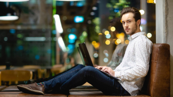 Computer Science, studia I stopnia, licencjackie i inżynierskie: Siedzący student z laptopem