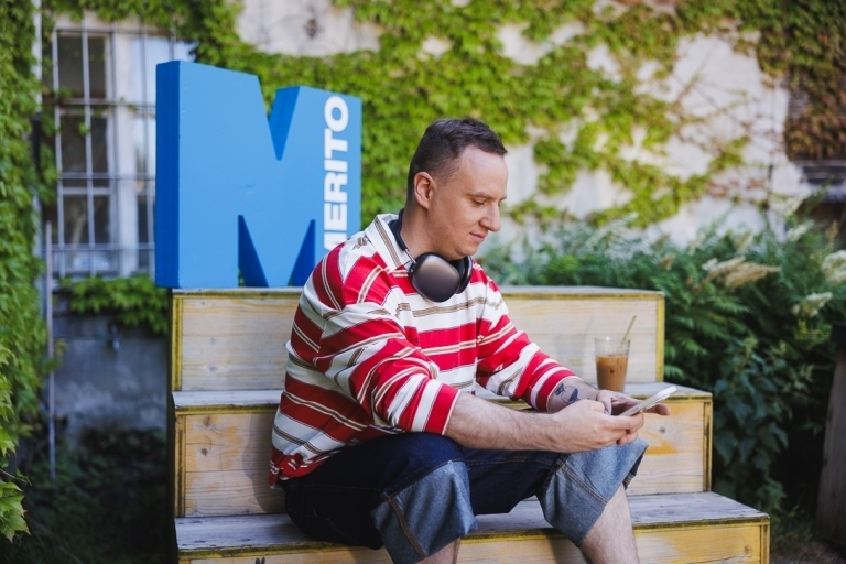Required language certificates | WSB Merito Warsaw University: Man leaning against the Merito logo