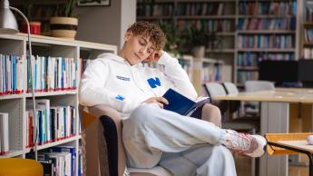 International Management, studia II stopnia, magisterskie: student w bibliotece czytający książkę