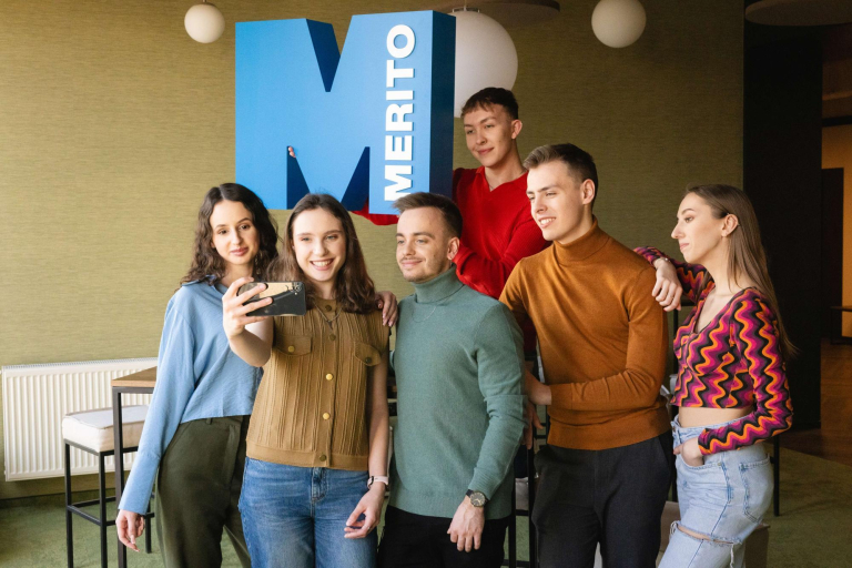 University without barriers | WSB Merito Wrocław University: Grupa studentów robiąca selfi na tle sygnetu merito