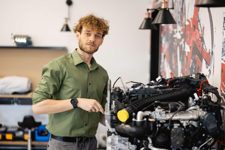 Who we are | WSB Merito Wrocław University: CLM mężczyzna naprawia silnik w centrum lean management