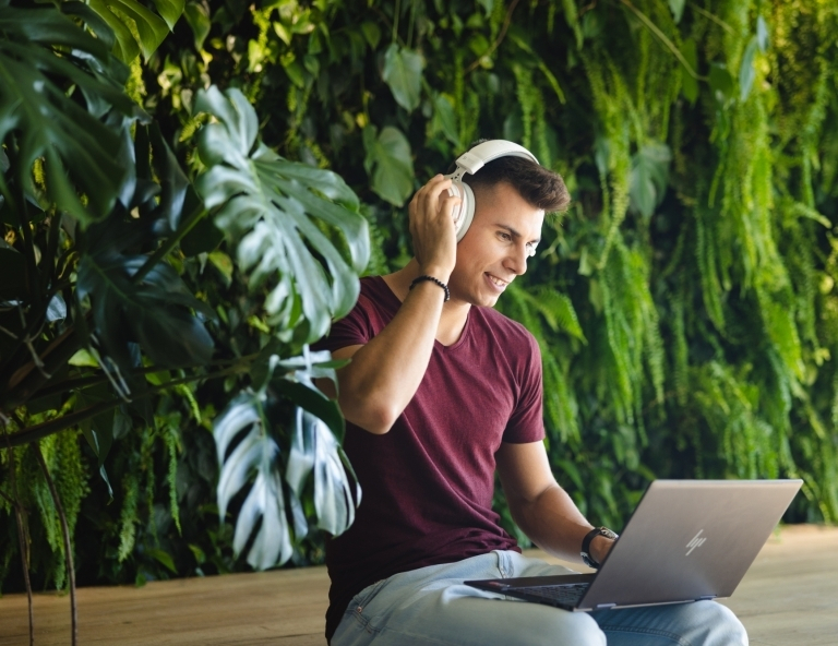 Language courses for foreigners | WSB Merito Wrocław University: A man wearing headphones holding a laptop podcast