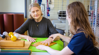 Fizjoterapia sportowa | Studia podyplomowe w Gdańsku | Uniwersytet WSB Merito w Gdańsku: Studentka prowadzi ćwiczenia fizjoterapeutyczne seniorce
