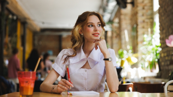 Zarządzanie zasobami ludzkimi – z certyfikatem FU | Studia II stopnia ze studiami podyplomowymi  | Uniwersytet WSB Merito w Gdańsku: Studentka notuje coś w zeszycie w kawiarni przy soku