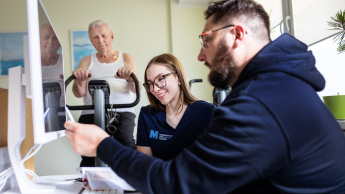 Zrównoważony rozwój i polityka klimatyczna | Studia I stopnia w Gdańsku | Uniwersytet WSB Merito w Gdańsku: Studentka słucha wykładowcy, które przedstawia jej wyniki na komputerze