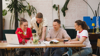 Zarządzanie | Studia II stopnia ze studiami podyplomowymi w Gdańsku | Uniwersytet WSB Merito w Gdańsku: Studenci przy stoliku w kawiarni. Wspólnie pracują nad projektem przy laptopie