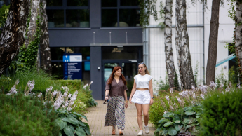 Windykacja i zarządzanie wierzytelnościami | Studia podyplomowe w Gdańsku | Uniwersytet WSB Merito w Gdańsku: Dwie osoby wychodzą z budynku uczelni WSB Merito w Gdansku