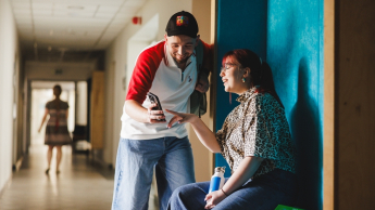 Rachunkowość i controlling | Studia II stopnia ze studiami podyplomowymi  | Uniwersytet WSB Merito w Gdańsku: Studenci na korytarzu Uniwersytetu w Gdyni, sprawdzają informacje w komórce