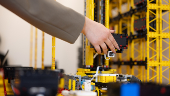 Menedżer logistyki | Studia II stopnia ze studiami podyplomowymi  | Uniwersytet WSB Merito w Gdańsku: Ręka studenta przy makiecie