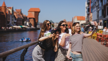 Zarządzanie sprzedażą i nowe media w turystyce | Studia II stopnia ze studiami podyplomowymi  | Uniwersytet WSB Merito w Gdańsku: Selfie studentek przy Motławie i Żurawiu