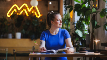 Zarządzanie przedsiębiorstwem | Studia I stopnia w Gdańsku | Uniwersytet WSB Merito w Gdańsku: Studentka w kawiarni przy książce