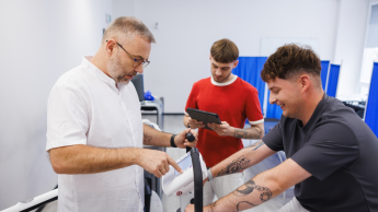 Zarządzanie w ochronie zdrowia | Studia podyplomowe w Gdańsku | Uniwersytet WSB Merito w Gdańsku: Medyk sprawdza wyniki na rowerku pacjenta