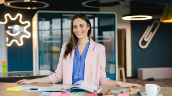 Rozwój produktów i usług w małej firmie | Studia podyplomowe w Gdańsku | Uniwersytet WSB Merito w Gdańsku: Kobieta przy katalogu, filiżance i notatkach