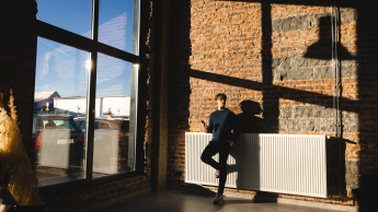 Administrowanie i zarządzanie nieruchomościami | Studia I stopnia w Gdańsku | Uniwersytet WSB Merito w Gdańsku: Student w dużej halowej przestrzeni ze ścianami z czerwonej cegły