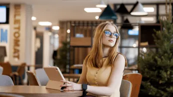 Bankowość 4.0 i finanse cyfrowe | Studia I stopnia w Gdańsku | Uniwersytet WSB Merito w Gdańsku: Studentka z tabletem przy biurku w holu 