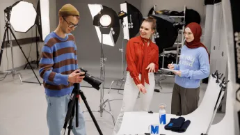 Marketing cyfrowy i grafika reklamowa | Studia I stopnia w Gdańsku | Uniwersytet WSB Merito w Gdańsku: Studenci w studio fotograficznym robią zdjęcia produktom