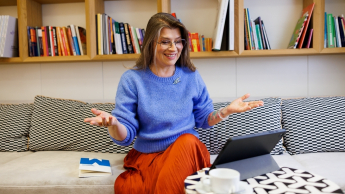 Inżynieria oprogramowania w JavaScript (TypeScript) | Studia podyplomowe w Gdańsku | Uniwersytet WSB Merito w Gdańsku: Kobieta siedzi na kanapie i uczestniczy w spotkaniu online